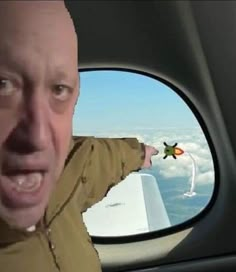 a man in the back seat of a car with his mouth open and an airplane flying above him