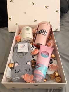 an open box filled with personal care items on top of a bed covered in pink flowers