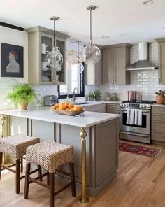 a kitchen with two stools in front of an island