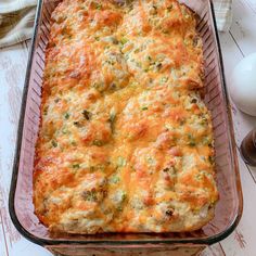 a casserole dish with meat and cheese in it on a table next to an eggplant container