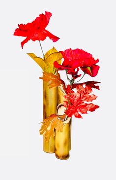 two vases with red flowers in them on a white background, one is gold and the other has orange leaves