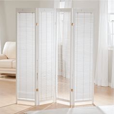 a room divider made out of white shutters