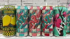 several cans of iced tea are lined up on a shelf