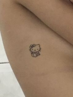 a hello kitty tattoo on the back of a woman's left arm and leg