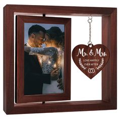 a wooden photo frame with a couple holding each other and a heart hanging from the front