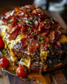 a close up of a plate of food with meat and cheese on it, topped with tomatoes