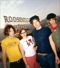 three people standing next to each other in front of a sign that reads rodeoland