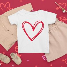 Celebrate Valentine's Day with Richland Creek! The adorable minimalist heart design in our BE MINE collection is perfect for anyone who enjoys chocolate, flowers, candy hearts, and all things romance and friendship.  Product Details: Our super-soft jersey toddler tee will have your kiddo feeling comfortable all year long. This high-quality t-shirt is perfect for layering and moves seamlessly from the playground to grandma's house and beyond. * 4.5 oz., 100% combed ringspun cotton fine jersey * T Cotton Top With Heart Graphic For Valentine's Day, Cotton T-shirt With Heart Print, Valentine's Day Cotton T-shirt With Heart Print, Cotton T-shirt With Heart Print For Valentine's Day, White Tops With Heart Graphic For Valentine's Day, Heart-shaped T-shirt For Valentine's Day, White Cotton T-shirt For Valentine's Day, Mother's Day Short Sleeve T-shirt With Heart Print, Valentine's Day Heart Print Tops