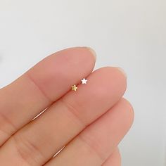 Ultra tiny star earrings/nose stud. The post is very flexible, so it's easy to bend in an L shape for the use as a nose piercing.  *Choose 1 piece or 1 pair.  *Choose Straight or L shape post *Gauge post: 0.6mm/22 gauge (very flexible) *Length post: approx. 1cm *Measurements: 2x2mm (tiny) *Material & color:    -Sterling silver comes with sterling silver backs.    -Gold plated over sterling silver with gold plated over sterling silver backs ---------------------------------- * More from us: https Minimalist Hypoallergenic Star Piercings, Minimalist Star-shaped Hypoallergenic Cartilage Earrings, Minimalist Hypoallergenic Star Cartilage Earrings, Tiny Star-shaped Piercings For Gift, Dainty Star-shaped Piercings As Gift, Hypoallergenic Star Piercings As Gift, Nose Studs, Earrings Star, Tiny Star