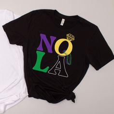 two t - shirts that say nola and one with a diamond on it, sitting next to each other