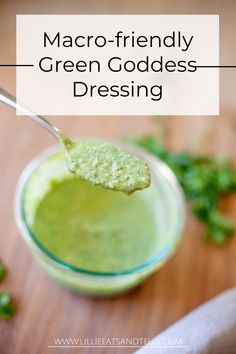 a spoon filled with green goddess dressing on top of a wooden table