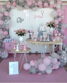 a pink and gray baby shower party with balloons, flowers, cake table and elephant decorations