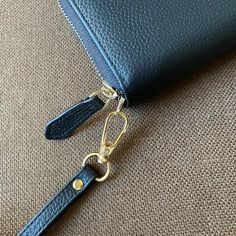 a blue wallet with a gold keychain hanging from it