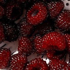 a pile of red raspberries sitting next to each other