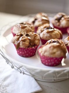 a white plate topped with muffins covered in chocolate