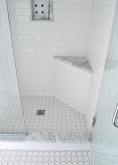 a white tiled bathroom with a shower stall