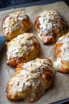 several pastries are on a baking sheet with some powdered sugar and almonds