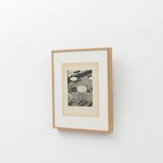 a black and white photo hanging on the wall next to a wooden framed artwork piece