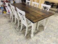 a wooden table with white chairs around it