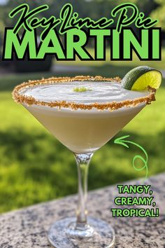 a margarita sitting on top of a table next to a grass covered field with the words key lime pie martini