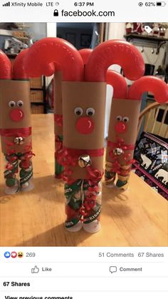 three toilet paper roll christmas decorations sitting on top of a wooden table next to each other