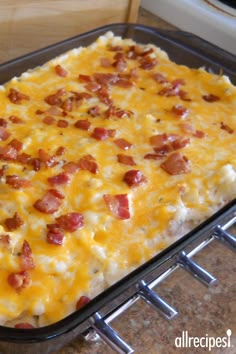 a casserole dish with cheese and bacon in it sitting on a counter top