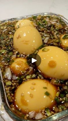 three eggs are in a glass dish with some seasoning on them and sprinkled with green onions