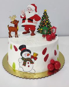 a decorated christmas cake with santa claus and snowman on top, surrounded by holiday decorations