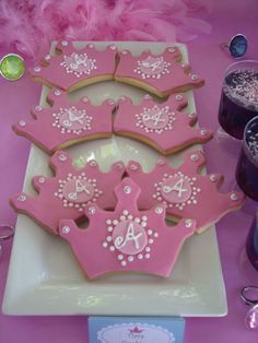 pink decorated cookies are on a white plate