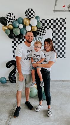 a man, woman and child standing in front of balloons