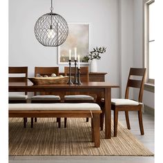 a dining room table with chairs and a bench