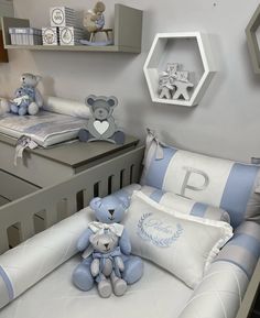 a baby's room is decorated in blue and white colors with teddy bears on the bed