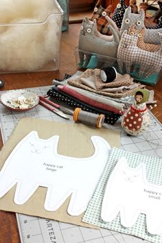 sewing supplies are laid out on a table with scissors and other crafting items in the background