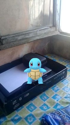 a nintendo wii sitting on top of a table next to an open box with a stuffed turtle in it