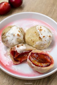 plums and ice cream on a plate with some powdered sugar in the middle