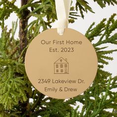 a personalized ornament hanging from a christmas tree with a house on it