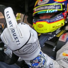 a person in a race car holding up their hand