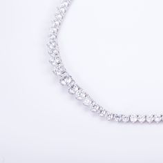 Timeless elegance with 123 exquisite diamonds, expertly hand-linked for seamless perfection. Featuring the highest color grade and a secure box clasp, this necklace is a true work of craftsmanship. Enhance any outfit with this stunning luxury piece. Diamond is set in 14k solid recycled white gold Width: 5.5mm in the center, 3mm to the ends Setting: 3 prong Total gold 25g, based on 16" Closure: Box clasp with 1 hidden latch AG Conflict-free, socially responsible diamonds. Color: D-F, Clarity: VVS Luxury Exquisite Tennis Necklace With Prong Setting, Timeless Brilliant Cut Tennis Necklace Gift, Timeless Brilliant Cut Tennis Necklace As Gift, Luxury Diamond White Crystal Necklace, Timeless Diamond White Necklace In Cubic Zirconia, Luxury Cubic Zirconia Diamond Necklace With Brilliant Cut, Luxury White Gold Solitaire Necklace With Cubic Zirconia, Luxury Round Cubic Zirconia Diamond Necklace, Luxury Cubic Zirconia Solitaire Necklace For Formal Occasions