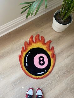 a pair of red shoes sitting on top of a floor next to a fire ball rug