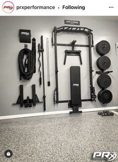 a home gym with various equipment on the wall and in front of it is a barbell rack