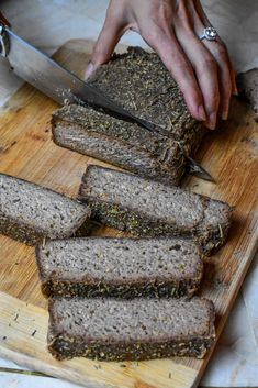 someone is slicing up some bread on a cutting board