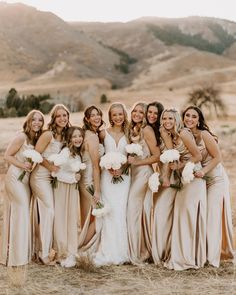 a group of women standing next to each other on top of a grass covered field