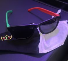 the sunglasses have been placed on top of a cloth with a red and green handle