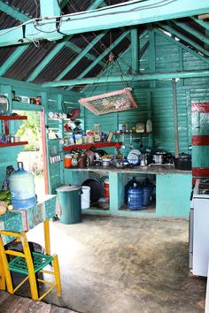 a kitchen with blue walls and shelves filled with pots, pans and other items