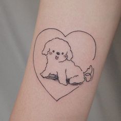 a small black and white dog sitting on top of a heart