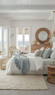 a white bedroom with wicker furniture and an ocean - inspired bedding is pictured in this image