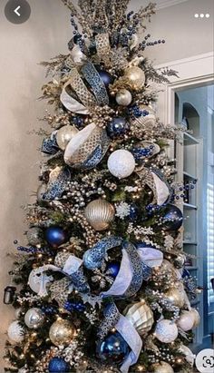 a decorated christmas tree with blue and silver ornaments