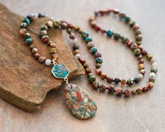 "Approx. 34\" L. Pendant size: 1.2\"x3\" Color, size, pattern may vary. Elevate your style with our enchanting Multicolored Blue Sea Sediment Imperial Jasper Necklace, featuring a substantial stone pendant for a bold and distinctive look. Meticulously handcrafted, this necklace is not just a stunning accessory but also a symbol of stability and healing. The large Sea Sediment Imperial Jasper pendant takes center stage. Known for its stabilizing energy, this gemstone promotes a sense of calm and balance. The necklace goes beyond mere fashion, offering a connection to the earth's energies and a shield of healing crystal protection. Measuring approximately 34 inches, the knotted design showcases the natural beauty of colorful Sea Sediment Imperial Jasper. Its rich hues are complemented by sma Crystal Protection Necklace, Crystal Protection, Beaded Boho Necklace, Long Necklace Boho, Small Necklace, Imperial Jasper, Crystal Bead Necklace, Jasper Necklace, Hippie Necklace