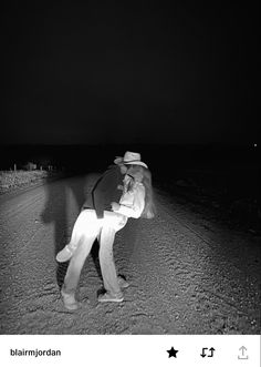 a man standing in the middle of a road at night with his back turned to the camera