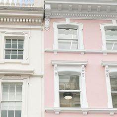 two different colored buildings with windows and balconies